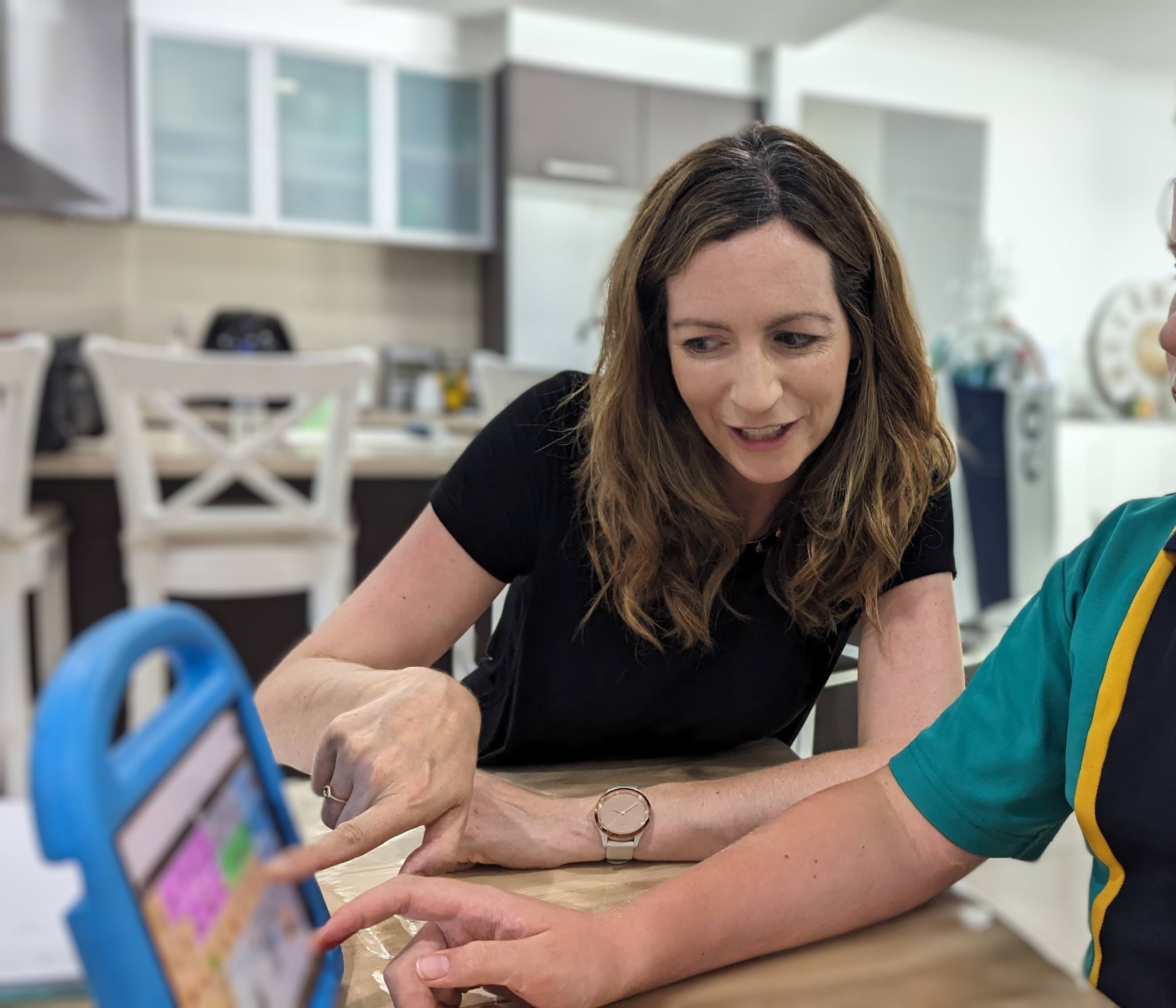 Aoife working with a child using an iPad communication device