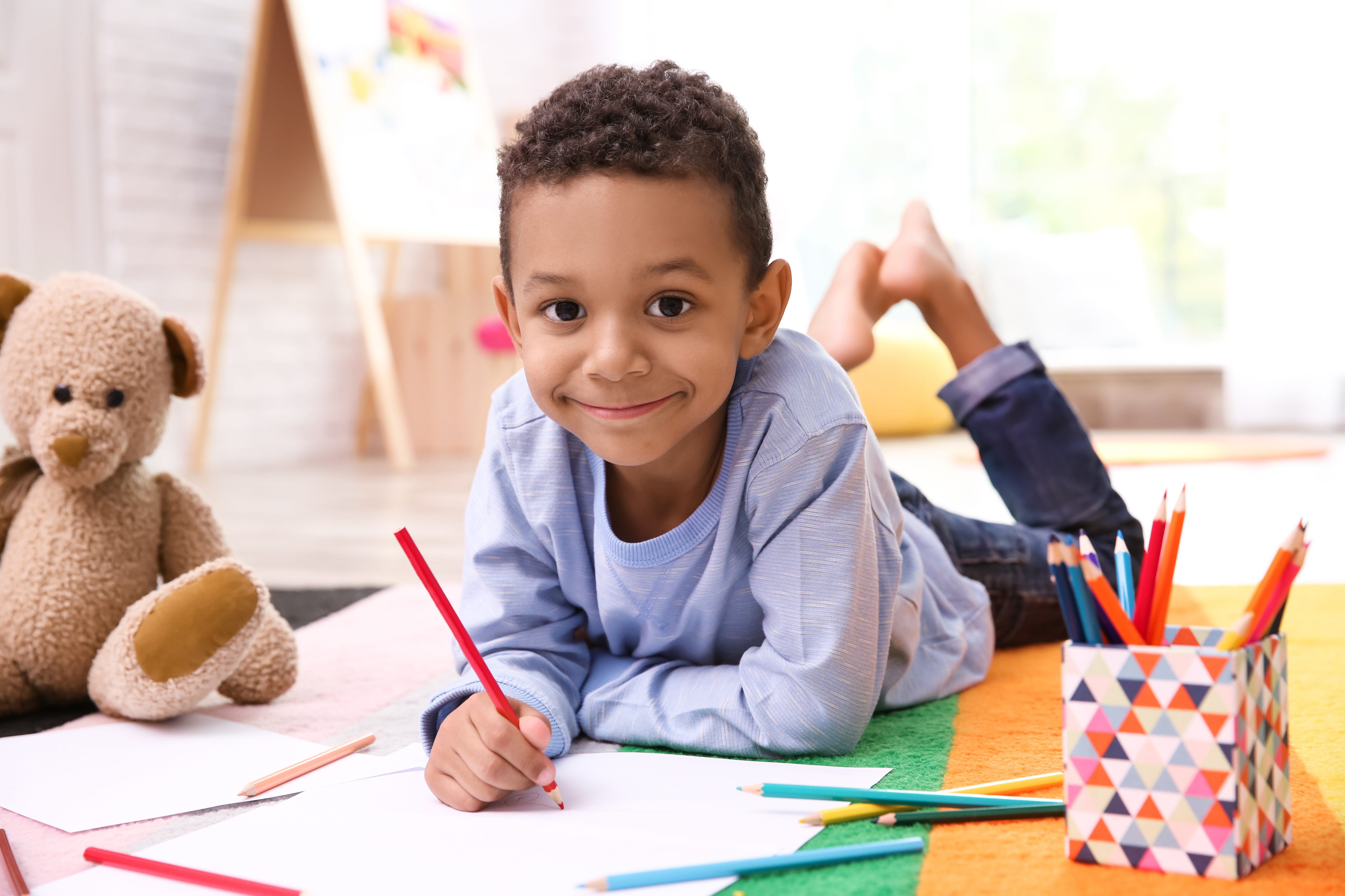 Young boy holding a pencil and drawing