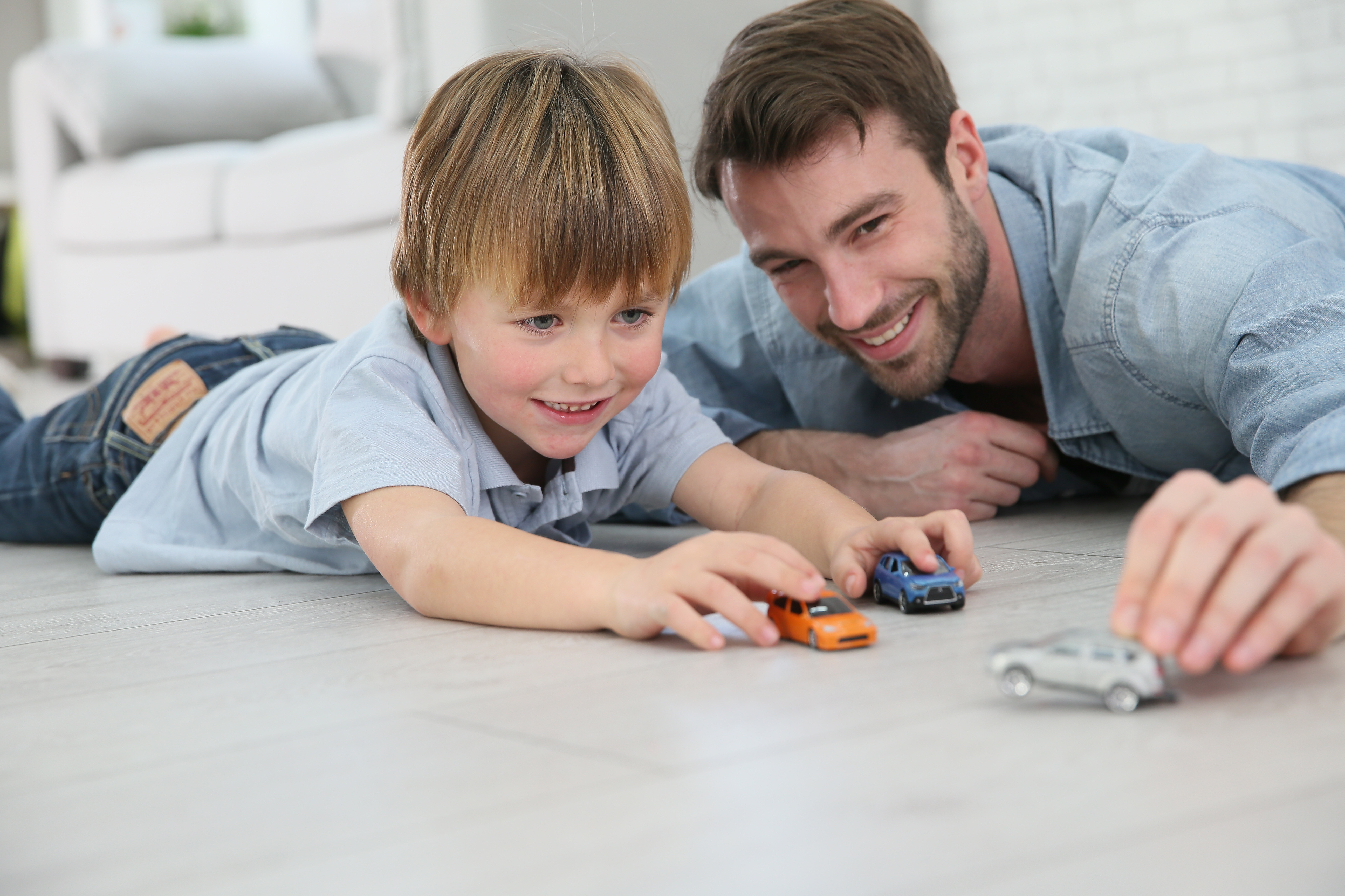 Father and child playing together with toy cars